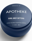 Apotheke earl grey bitters mini candle is featured in round dark blue container using white lettering on a white background.