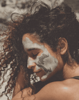 Person with green face paint embracing another person outdoors