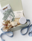 Gift box with tea packages, a jar, and decorative elements on a light background
