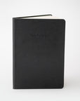 Black pocket notebook on white background.