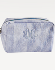 Rectangular cosmetic makeup bag with blue and white horizontal stripes and a top zipper closure.