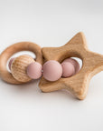 Blush star silicone and wood teether side featured in image with wooden star, round wood circle attached by a round circle made of 9 round pink silicone balls and one wooden round ball.