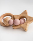 Blush star silicone and wood teether side featured in image with wooden star, round wood circle attached by a round circle made of 9 round pink silicone balls and one wooden round ball.