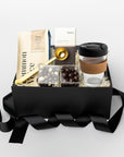 Gift box with coffee-themed items including a coffee cup, coffee beans, and a book on a white background.