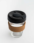 Clear tumbler with cork holder featured transparent tumbler with cork holder and black lid on a white background.