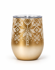 A gold-colored stemless wine tumbler with a white knit-patterned snowflake design and a clear lid, shown on a white background.