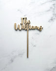 Custom name wooden cake topper is featured in champagne color personalized "The Williams" on a marble like background.