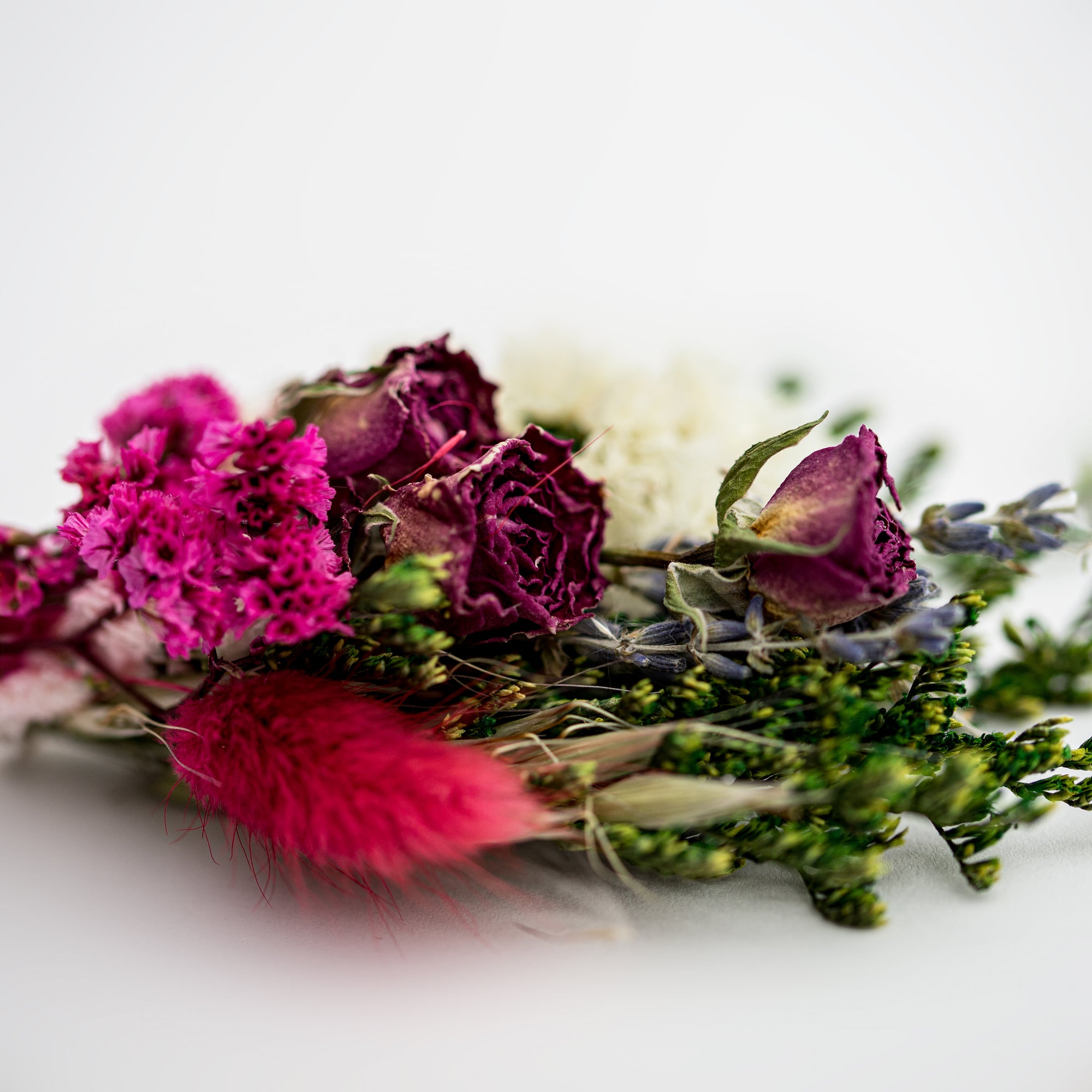 close up image of dried floral bundle on white background.