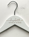 Engraved bride hanger in white personalized Elizabeth - mother of the bride on a marble-like background.