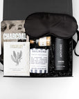 Gift set with sleep mask, charcoal soap, and other items on a white background