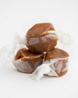 Gourmet brown taffy caramels, three pieces displayed on a clean white background.