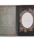 Grandma's Story memory keepsake and journal book. A vintage-style book page featuring a quote by Louisa May Alcott and an empty oval frame for a photo, surrounded by illustrations of leaves and branches.