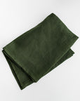 A green linen kitchen towel is featured, folded on a white background.