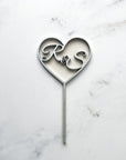 Heart wooden cake topper is featured with the initial R&S in silver in a marble like background.
