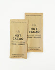 Two hot cacao hot chocolate from retreat drinks packet, beige colored with information in black lettering on a white background.