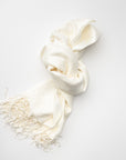 Ivory pashmina with fringed edges on a white background.