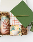 Gift box with a jar, notebook, and other items on a white background