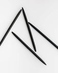 Four minimalist black pens are featured on a white background.