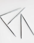 Five minimalist silver pens that have a round shape are featured on a white background.