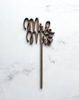Mr & Mrs wooden cake topper featured in a marble-like background.