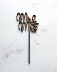 Mr & Mrs wooden cake topper featured in a marble-like background.