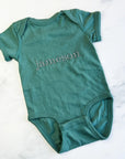 Name embroidered onesie featured in basil color personalized in champagne thread with the name Jameson on a marble like background.