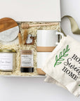 Gift set with a mug, tea, candle, and towel on a white background