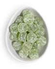 Pear italian ice gummies from Sugarfina are featured several of them in round and green colored in a ceramic white dish on a white background.