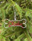 Personalized dog ornament image,dog-bone-shaped outline,in a silver aluminum wire with the name Charlie in the center in red aluminum wire. It has a christmas tree as a background.