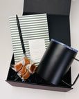 petite work from home gift box shown in image with black pen, taffy gourmet caramels, vita small notebook and black camo mug.