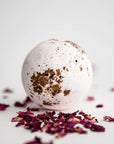 Rose Petal Bath Bomb, featured surrounded by rose petals on a white background.