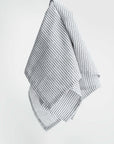 Stripped linen kitchen towel featured in its white and black lines design on a white background.