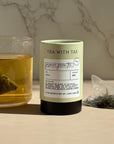 Tea packaging with a glass of tea and tea bag on a marble background