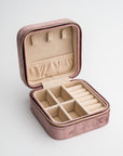 Velvet jewelry box in mauve color open with brown inside.