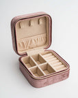 Velvet jewelry box in mauve color open with brown inside.