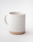 White ceramic mug stone-tan bottom with speckles featured on a white background.