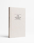A light beige-colored book titled "The Five-Minute Journal" is displayed against a plain white background.