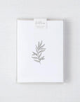 Our botanical card box set is featured. A minimalist, monochromatic sketch presents a sprig of delicate leaves centered on a stark white rectangular card, set against a neutral, textured backdrop.