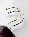 Two dark wooden hangers, gold and silver hooks.