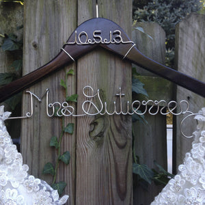 Dark wooden hanger with personalized date and base wire shaped into personalized name
