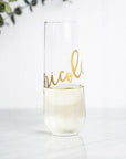 personalized champagne flutes, personalized transparent glass, personalized with the name Nicole in gold lettering in a white background with a green branch in the corner.