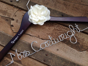 Dark wooden hanger with satin flower and silver hook. Personalized base wire shaped into name