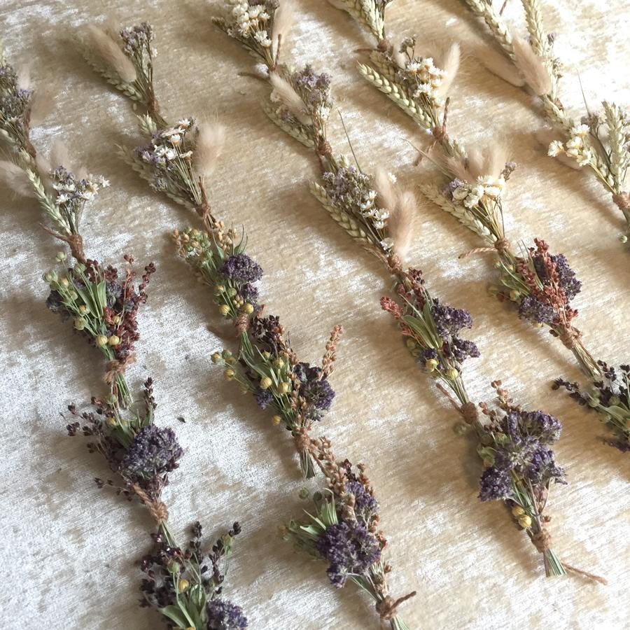 multiple dried floral bundles spaced out shown on a beige background