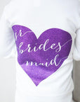 The image shows the back of a girl wearing a white hoodie featuring a jade-colored heart with the words "Jr. Bridesmaid" in script cut out from it. On a white background.