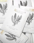 Several formulary 55 Sea Mineral Foot Soak in a white packet, with black and gold text, and a black plant graphic.