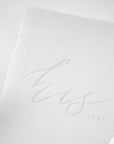 Close up of his vow book grey linen book with the letters his vows pressed.