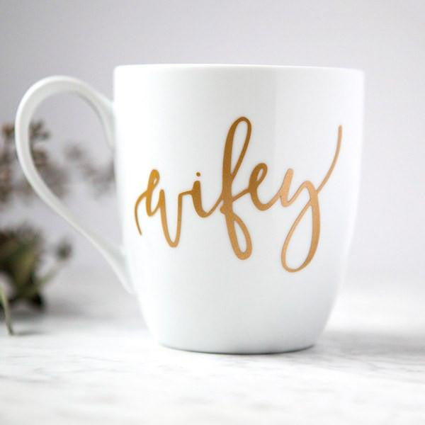 White ceramic mugs, two 15 oz mugs, "hubby" in black script font, "wifey" in gold script font