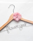 custom flower girl dress hanger, light wood hanger with flower girl in silver aluminum wire with pink chiffon flower on a white background.
