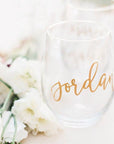Stemless Wine Glass, shown in the image, is a transparent wine glass personalized with the name Jordan. Accompanied by white roses.