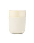 Cream colored ceramic tumbler with protective silicone covering.